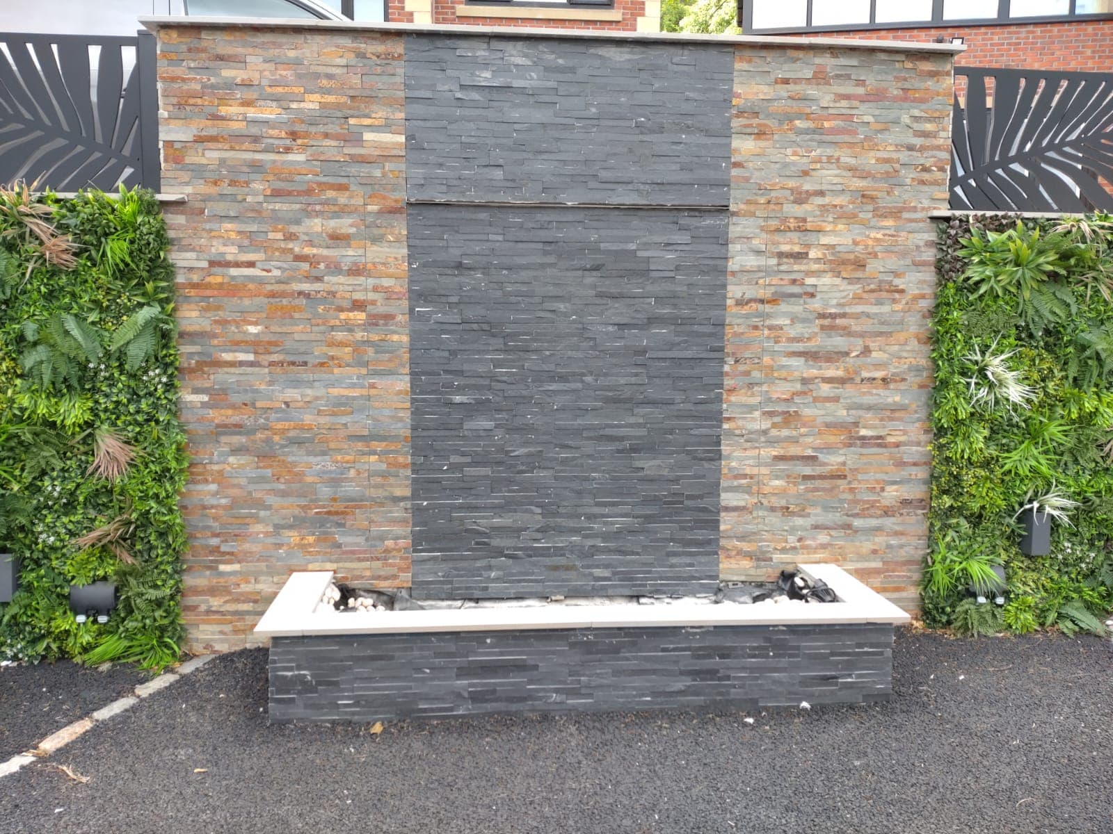 Slate and stacked-stone water feature with a living wall behind