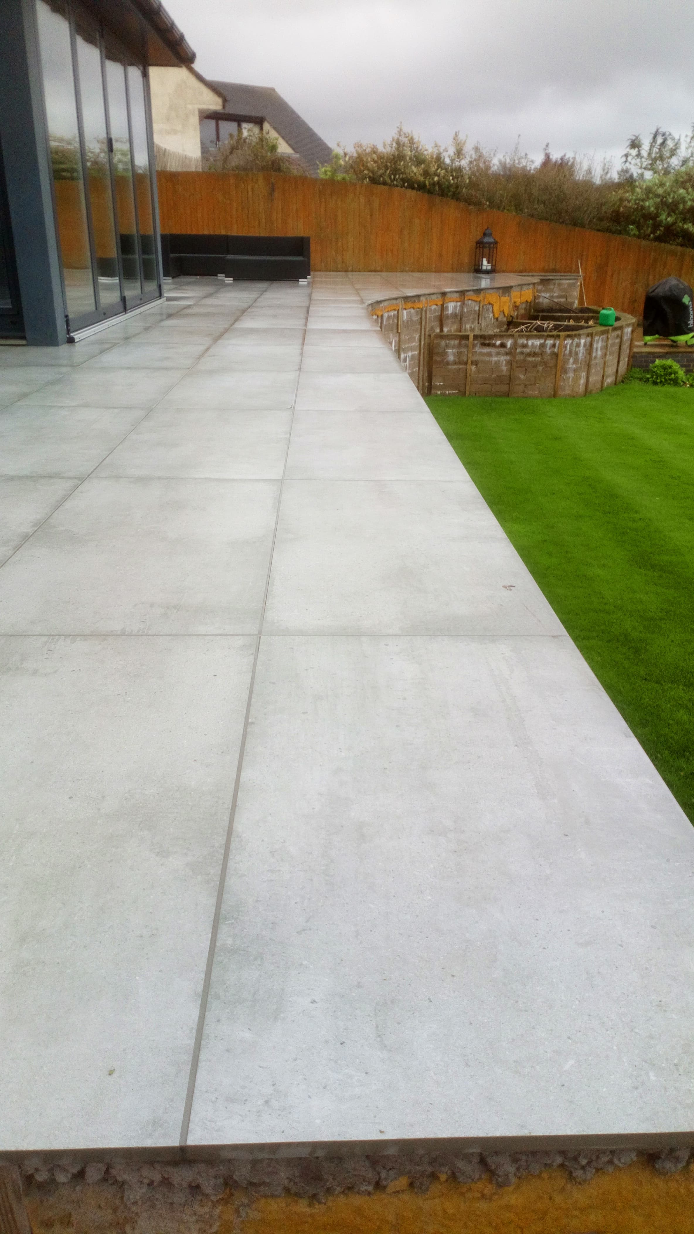 Curved porcelain patio finished, looking back toward bifold doors