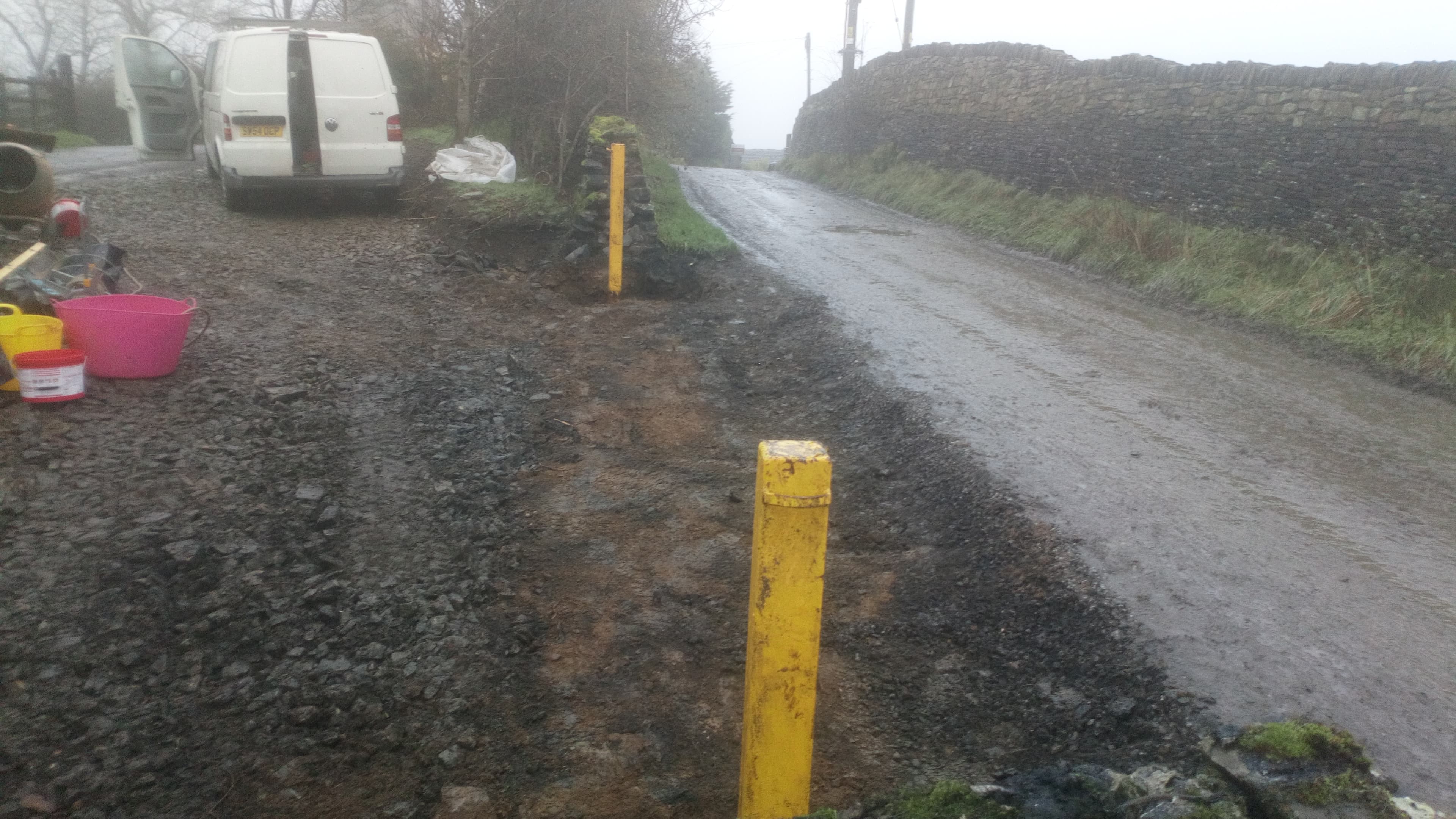 Higher Leafield Barn before work — wet muddy track with yellow bollards and a white van