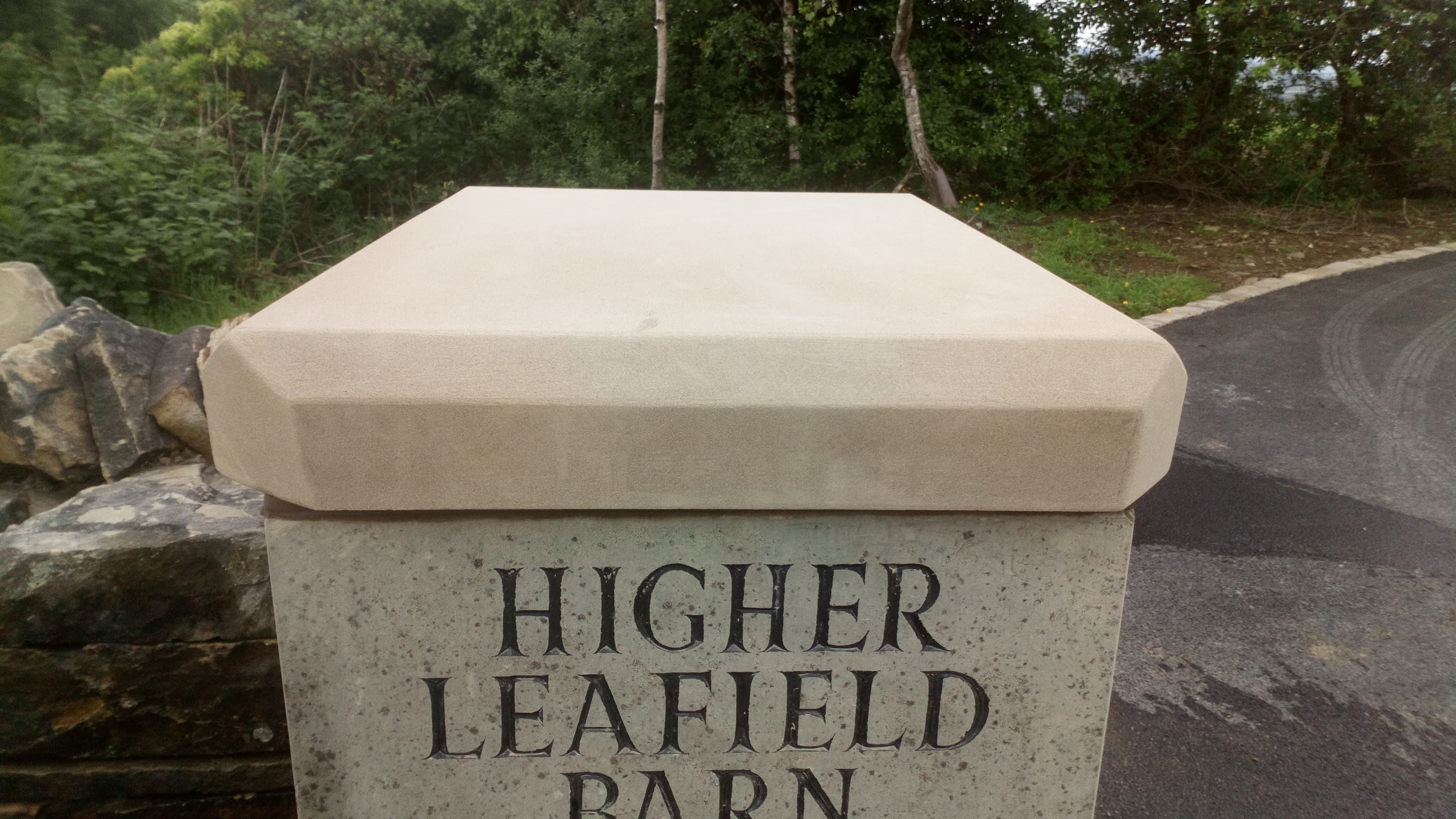 Close-up of the carved Higher Leafield Barn name stone set into the gatepost