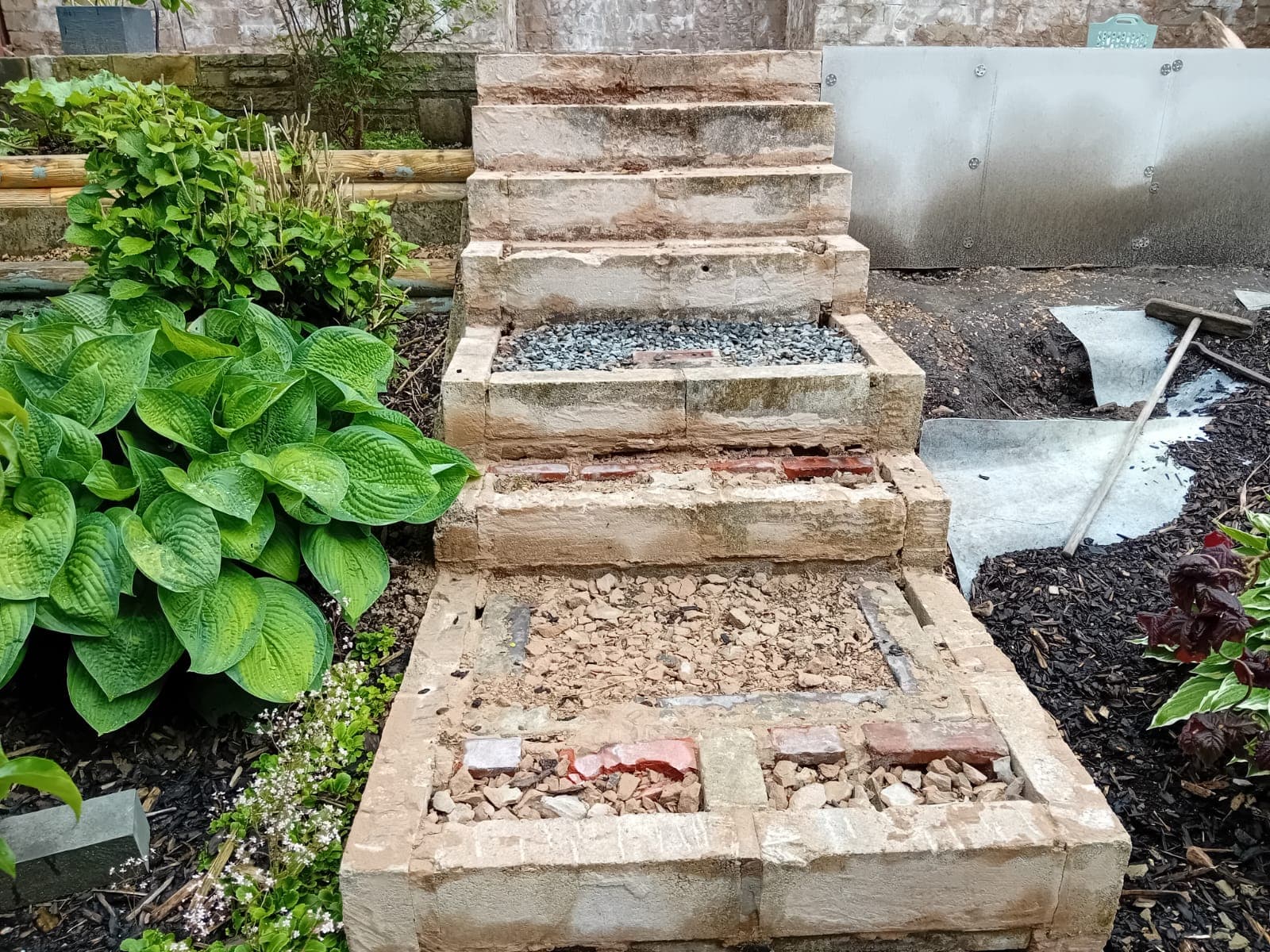Sandstone steps being rebuilt from the bedrock up, with rubble inlay visible